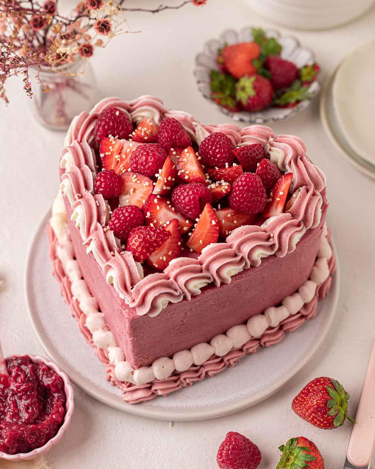 Beautiful heart-shaped cake with fresh strawberries and cream