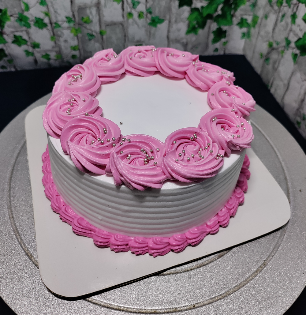 Elegant white cake beautifully decorated with fresh strawberries and pink roses